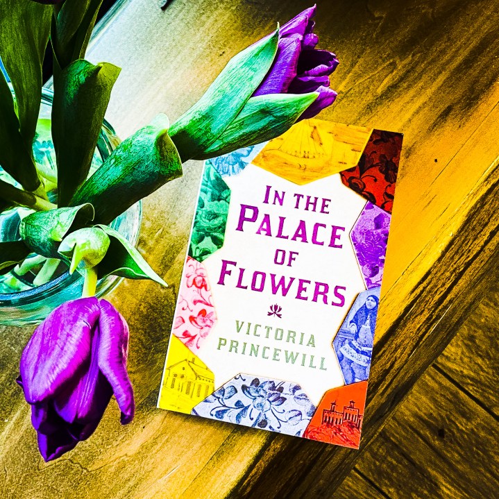 In The Palace Of Flowers book next to flowers